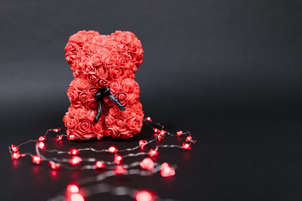 Elegant red rose bear surrounded by glowing string lights, perfect for Valentine's Day gift themes.